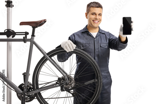 Bycicle mechanic smiling and holding a mobile phone