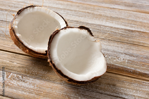 A view of a cut open coconut on a wooden surface table.
