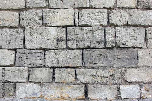 The texture of old masonry. The wall is made of white stone.