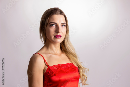 Portrait of a beautiful young woman in red lingerie. White background