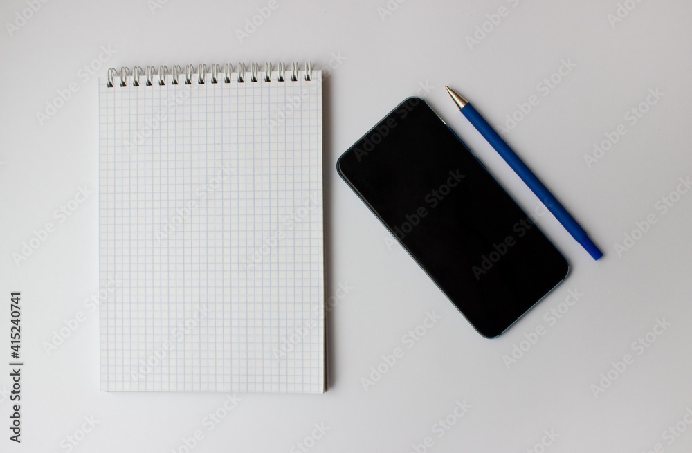 notebook and smartphone lie on a gray background notebook and smartphone lie on a gray background