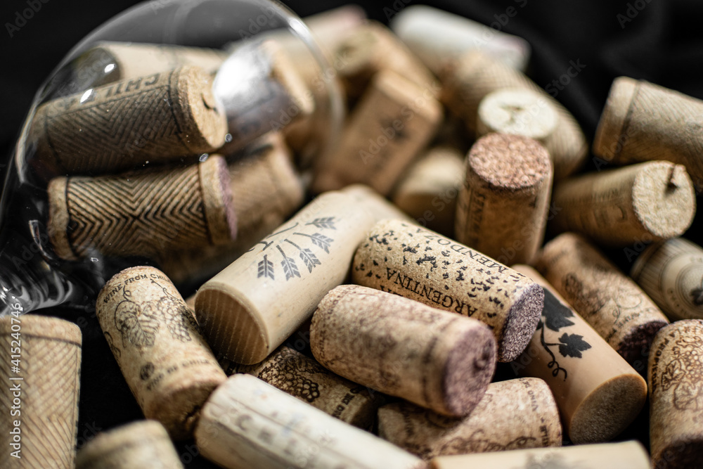 Bunch of wine corks and a bottle over a black blanket

