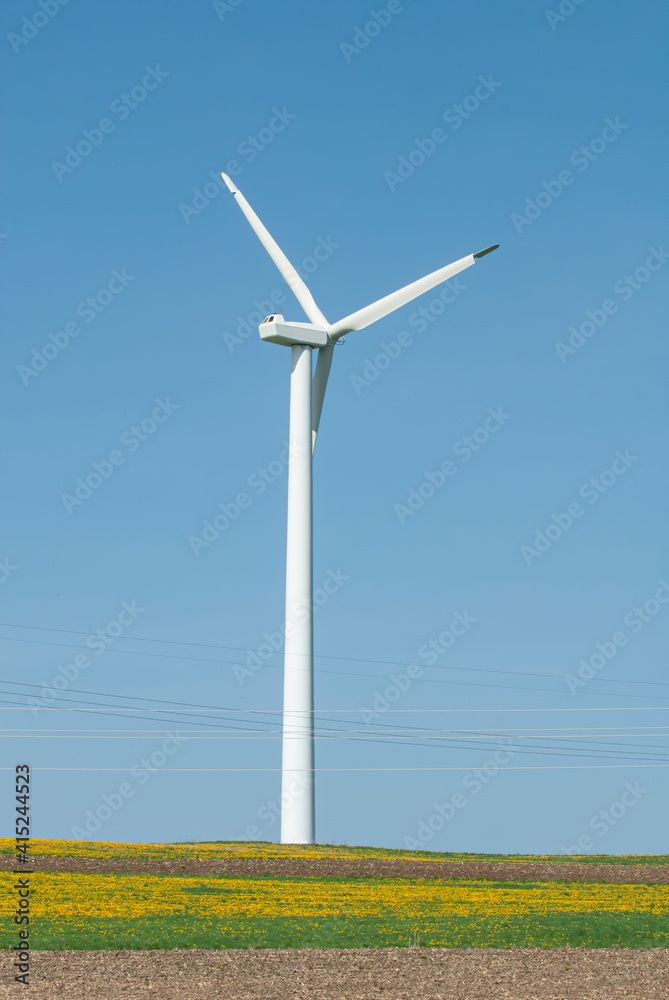 wind tower on farmland with powerlines wind tower on farmland with powerlines