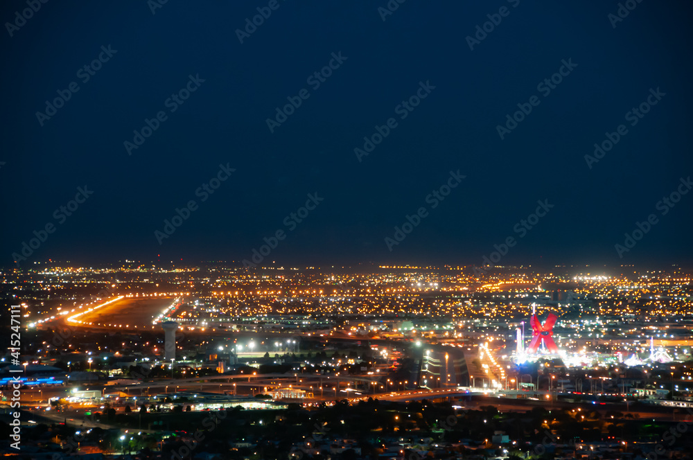 Night view of the international border between the US and Mexico in El Paso, Texas, seen from Scenic Drive. Visible are the Rio Grande, an entry bridge, and the wall between the countries.