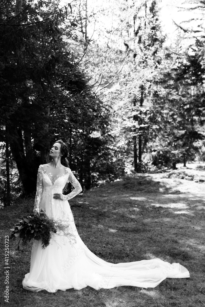 The bride in a white beautiful long dress, holding a wedding bouquet The bride in a white beautiful long dress, holding a wedding bouquet