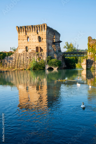 The beautiful medieval village of Borghetto di Valeggio sul Mincio. Detail of the river medieval tower with the bridge the swans and the medieval buildings. Verona  Veneto  Italy