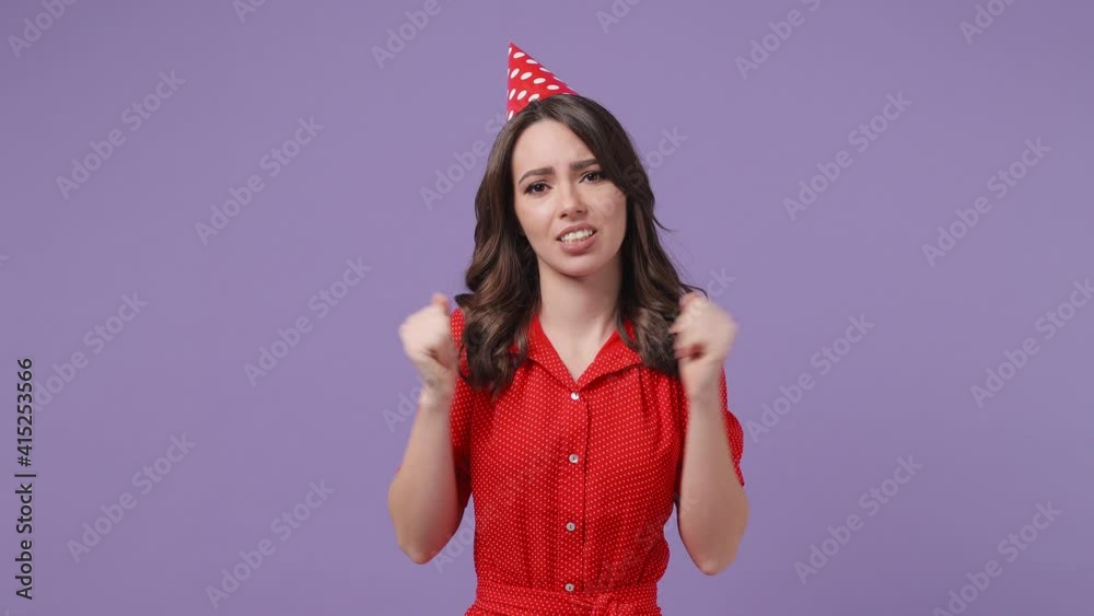 Confused puzzled brunette young woman 20s in red dress birthday hat posing isolated on violet purple background in studio. Celebrating holiday party people emotions concept. Spreading hands say oops Confused puzzled brunette young woman 20s in red dress birthday hat posing isolated on violet purple background in studio. Celebrating holiday party people emotions concept. Spreading hands say oops