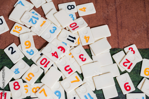 Rummi game tiles laying on a table simulating wood, in a mosaic style
