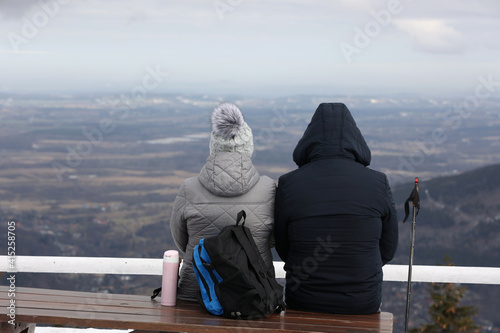 Daleko przed siebie patrzy para ludzi w górach. 