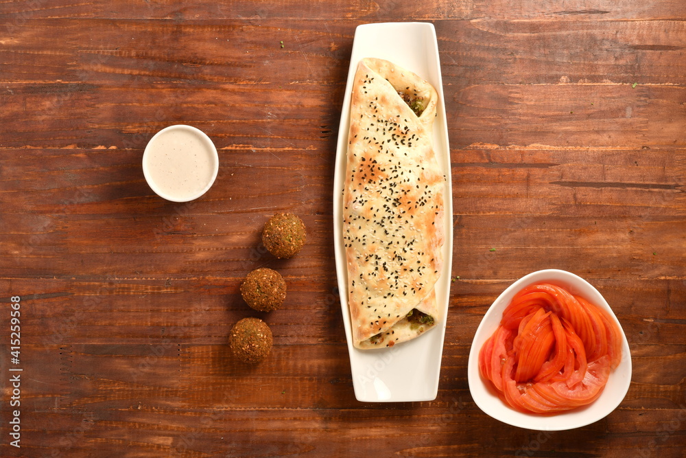 Arabic Traditional Ramadan , Kebab Roll Wrap , salad and hot pepper pickles on wooden background. Arabic Traditional Ramadan , Kebab Roll Wrap , salad and hot pepper pickles on wooden background.