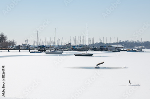 A scene of White Rock Lake in Dallas Texas with sailboats in view after a hard freeze and snow storm in February 2021