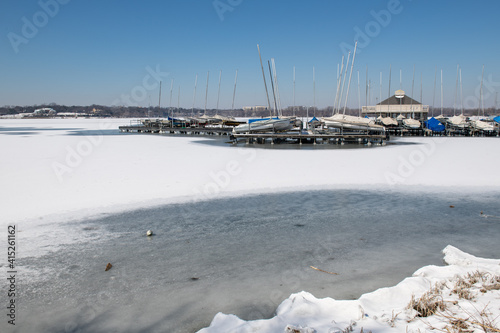A scene of White Rock Lake in Dallas Texas with sailboats in view after a hard freeze and snow storm in February 2021