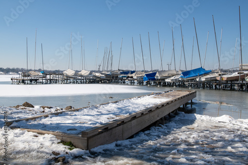 A scene of White Rock Lake in Dallas Texas with sailboats in view after a hard freeze and snow storm in February 2021
