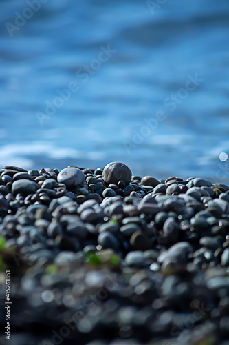 Smooth pebbles on the beach. A lone stone stands out against the background of the beach.The concept of balance and harmony. Wallpaper, cover and postcard.