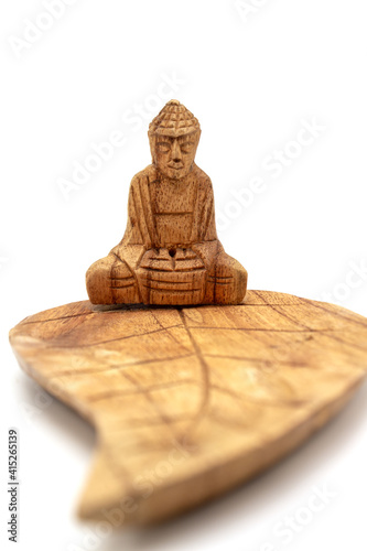 Photography Isolated photos of a wooden carved incense stand buddha on a lotus leaf