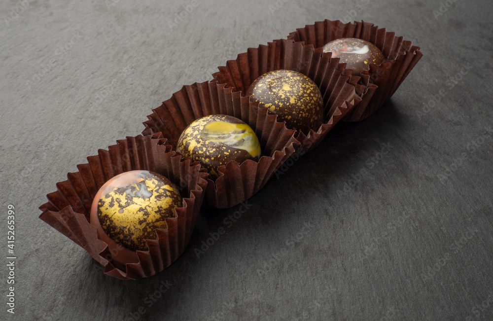 Chocolate candies with abstract patterns on a black background Chocolate candies with abstract patterns on a black background