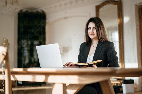 Works in a modern office. New project at work. The lawyer is sitting next to the laptop. Copy space. Accountant Manager Student beautiful brunette. A woman writes down important things.