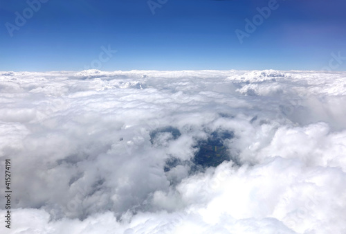 Beautiful sky landscape with view from the aircraft above dense white clouds high in the stratosphere on a sunny day horizontal photo