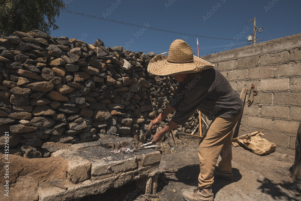 Blacksmith working in the forge with incandescent metal to create chisels by striking the metal into the tool. Blacksmith working in the forge with incandescent metal to create chisels by striking the metal into the tool.