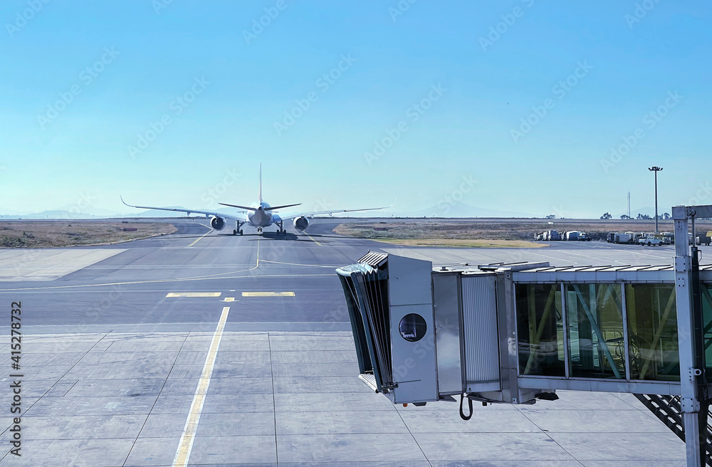 Jet bridge with Aircraft driving by the runway before airplane takeoff ...