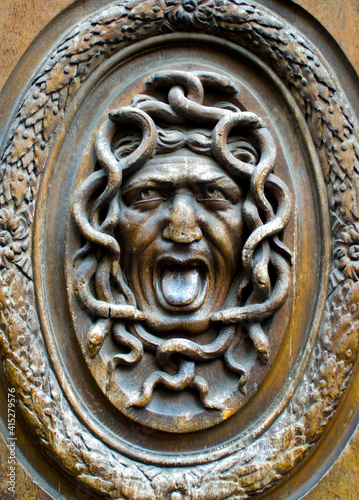 ornate medusa wood carved design on an old door