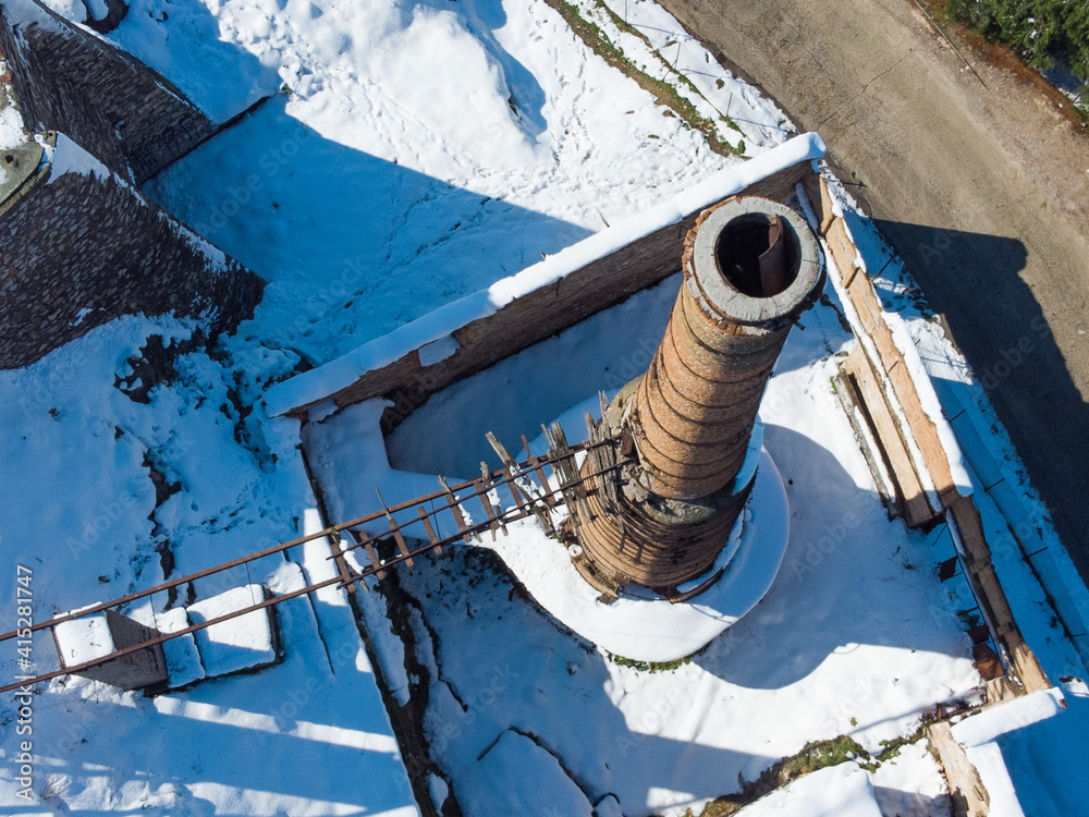 Obraz premium Aerial photo of chimney of an old abandoned factory during the Medea snowstorm in Athens, Galatsi