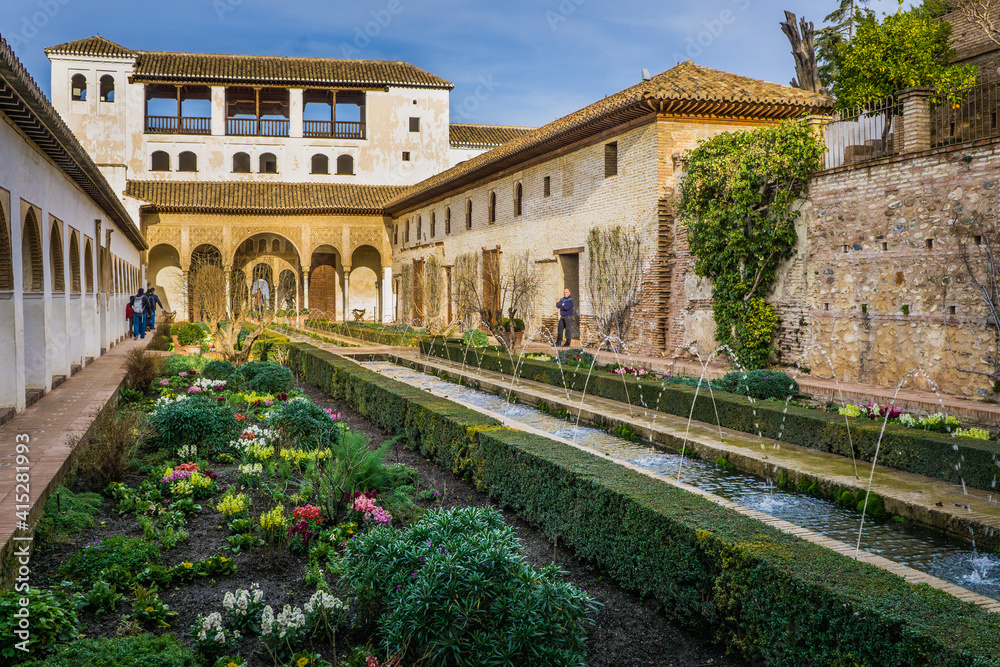 Obraz premium Inside the Generalife palace (part of the Alhambra complex in Granada, Spain), gardens and fountains welcome the visitor. 