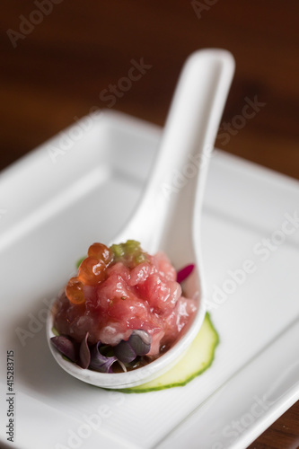 Tuna and salmon roe appetizer on white spoon & white plate background photo