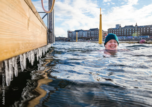 Canvas Print Smiling Woman Swimming By Icicles In Open Water Copenhagen, Denmark