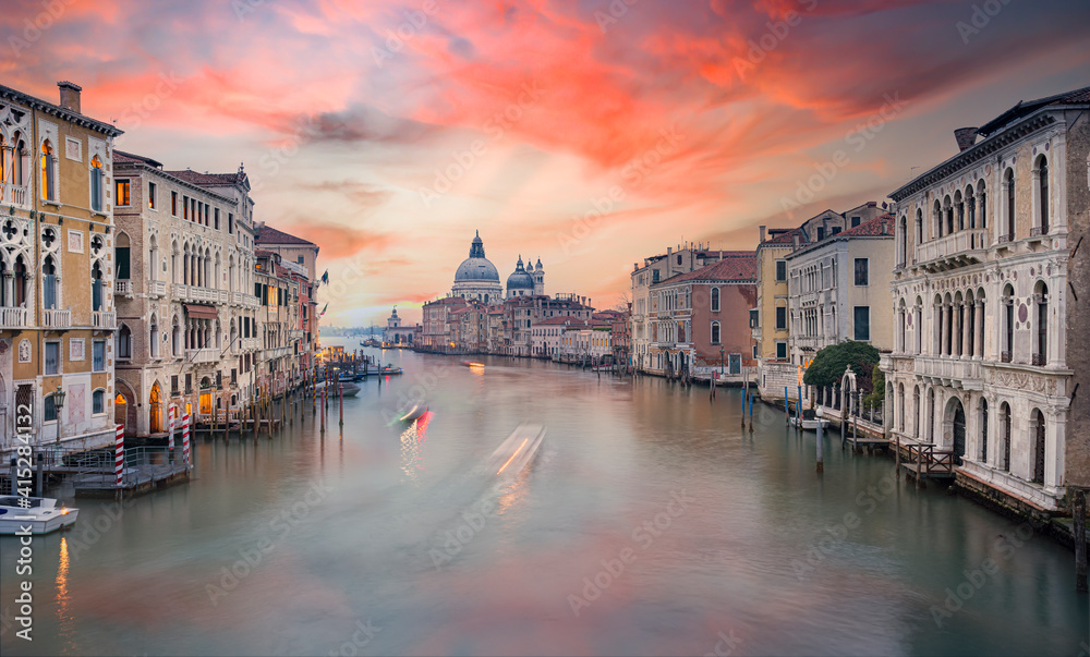 Stunning view of the Venice skyline with the Canal Grande and the Basilica Santa Maria Della Salute in the distance during a beautiful sunrise. Venice, Italy.