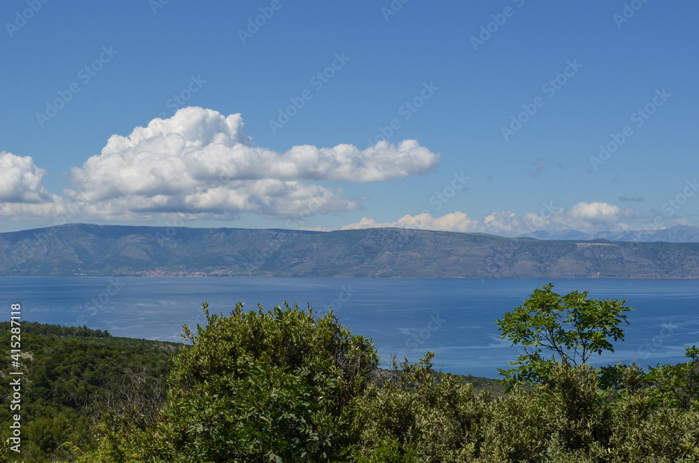 Beautiful landscape in Hvar, Croatia with greenery, sea, hills and clouds