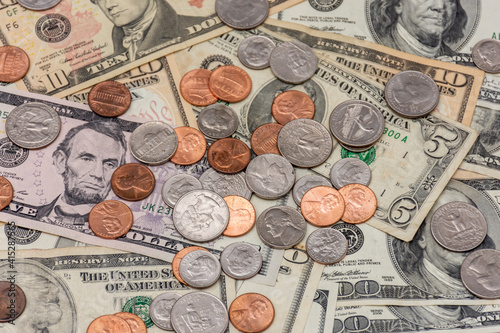 Many US bills and coins on a table.