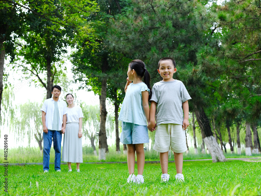 Fototapeta premium Happy family of four playing in the park