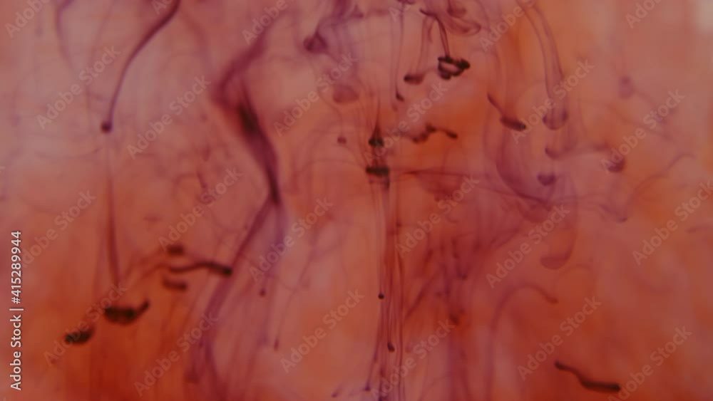 Underwater background with falling purple and red drops spreading beautiful waves Underwater background with falling purple and red drops spreading beautiful waves