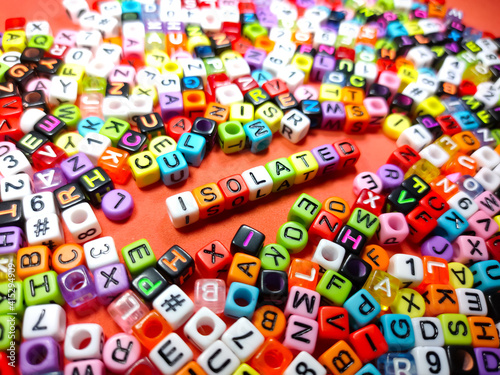 Selective focus.Colorful dice with word ISOLATED on red background.Shot were noise and film grain.