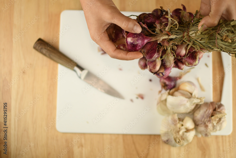hands of a person with red onion picking on white board in the kitchen hands of a person with red onion picking on white board in the kitchen