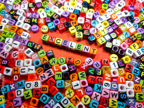 Selective focus.Colorful dice with word EXCELENT on red background.Shot were noise and film grain.