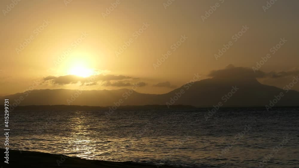 Couché de soleil avec le reflet sur la mer et des montagnes en fond Couché de soleil avec le reflet sur la mer et des montagnes en fond