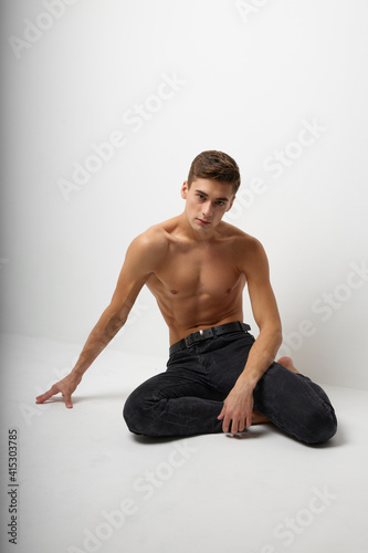 Man sitting on the floor with a naked torso elegant style Studio attractiveness model