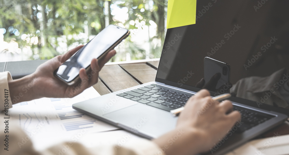 Financial businesswomen use laptop and smart phone to analyze marketing strategies and real estate data to reduce company taxes for their customers, Accounting and Tax concept. Financial businesswomen use laptop and smart phone to analyze marketing strategies and real estate data to reduce company taxes for their customers, Accounting and Tax concept.