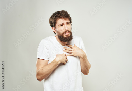 Guy on a white background gestures with his hands in a T-shirt cropped view