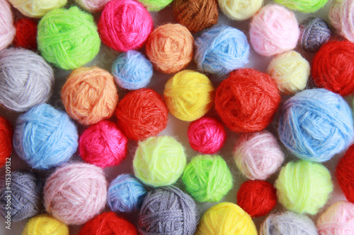Colorful background of multi-colored yarn for knitting, crocheting. Lots of balls of yarn for knitting in all colors. The concept of handmade, needlework and craft. Top view. Flatlay. Copyspace.