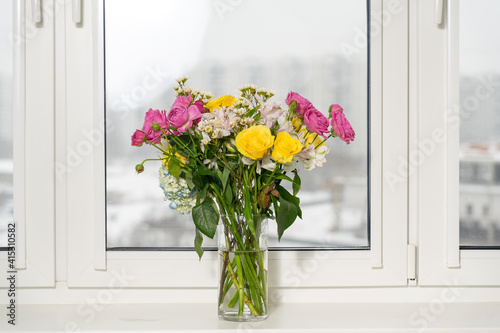 Beautiful flowers in vase with light from window