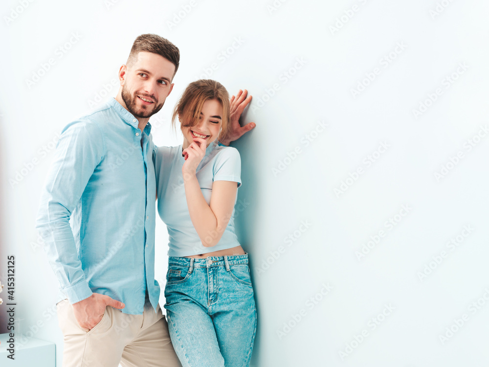 Smiling beautiful woman and her handsome boyfriend. Happy cheerful family having tender moments near light blue wall in studio.Pure models hugging.Embracing each other.Love concept Smiling beautiful woman and her handsome boyfriend. Happy cheerful family having tender moments near light blue wall in studio.Pure models hugging.Embracing each other.Love concept