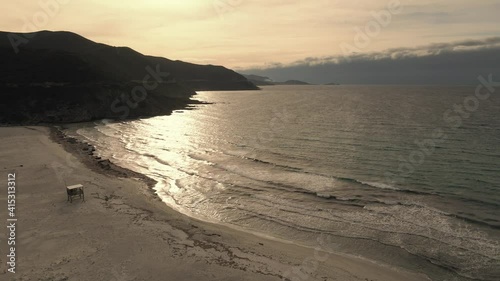 Aerial view of evening sunshine reflecting on the Mediterranean sea at Ostriconi beach in the Balagne region of Corsica with Ile Rousse in the distance photo