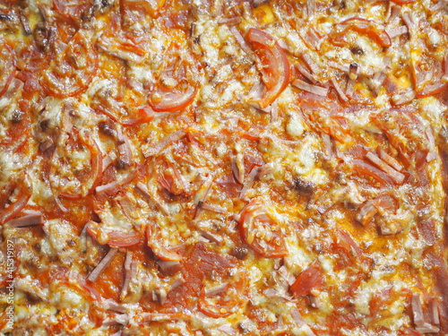 Bright handmade oven baked pizza with grilled tomatoes, cheese, onions and sausage.