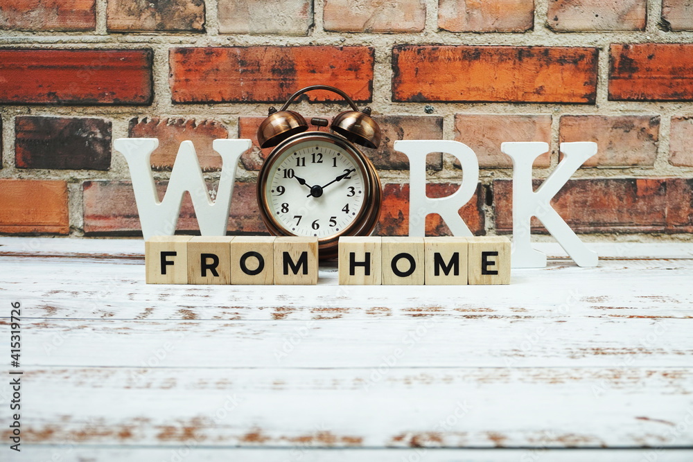 Fototapeta premium Work from Home alphabet letters with alarm clock on wooden background