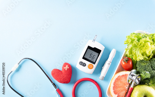 фотографія Top view of healthy food in plate with stethoscope and red heart for cholesterol diet and diabetes control on pastel blue background