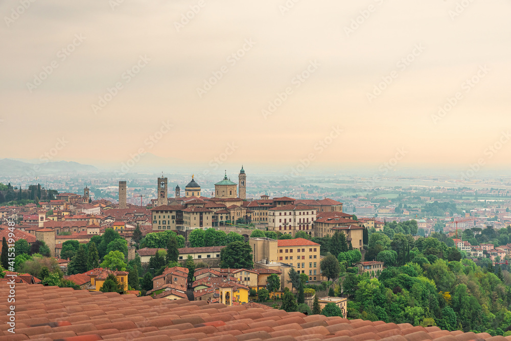 Beautiful view on medieval old town Bergamo, Lombardy, Italy from the rooftop with roof tiles on sunrise