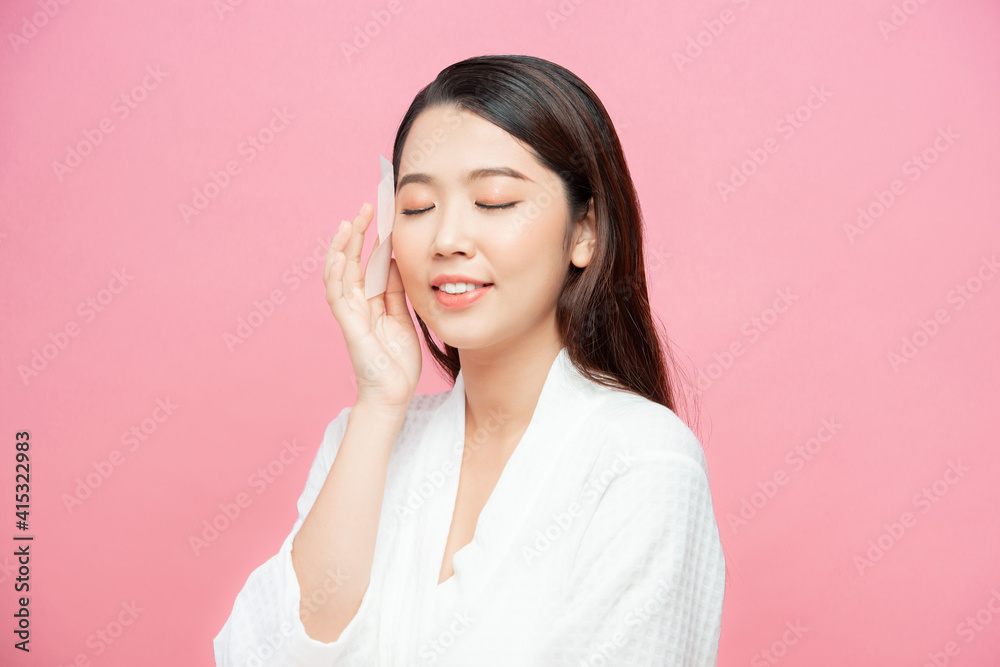 Skin Care. Beauty Face. Woman removing oil from face using blotting papers Skin Care. Beauty Face. Woman removing oil from face using blotting papers